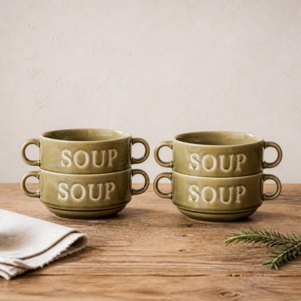 Vier groene Soup soepkommen gestapeld in twee stapels op een eiken tafel