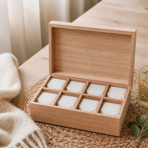 Houten theedoos met 8 vakken vol theezakjes op een zeegras placemat