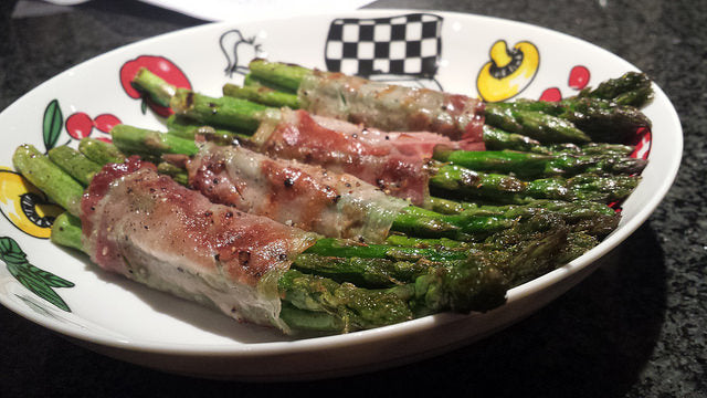 Crispy ham rolls from the grill with green asparagus tips