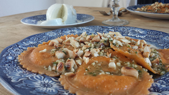 Creamy eggplant puree with fresh ravioli, pesto and crunchy almonds